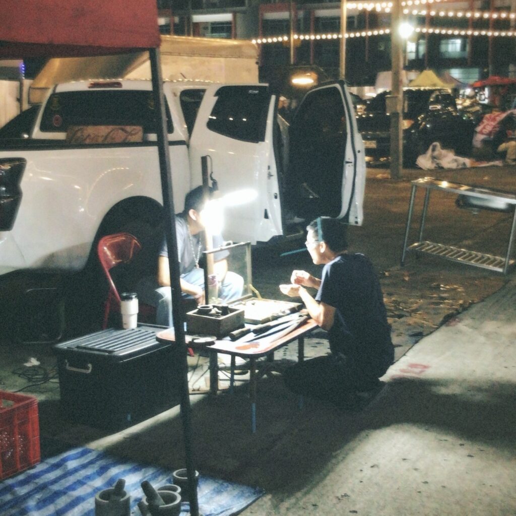 タイのお守り、「プラクルアン」をじっくりと眺める人。これもタイの一部。